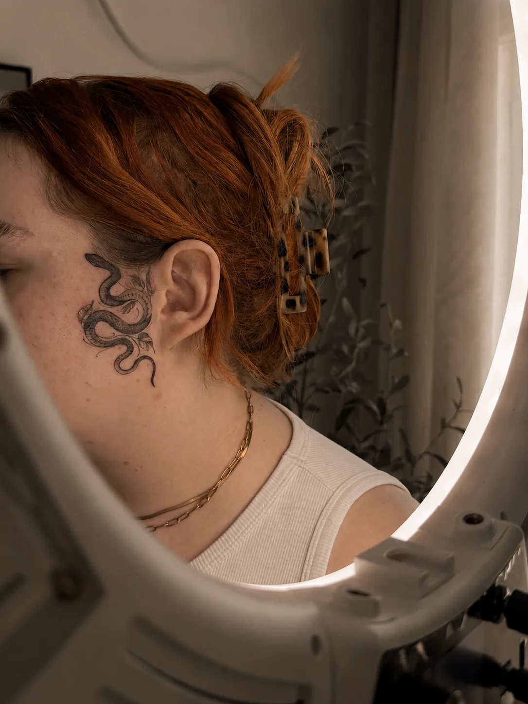 Feines Tattoo von Elena hinter dem Ohr mit ornamentalem Motiv