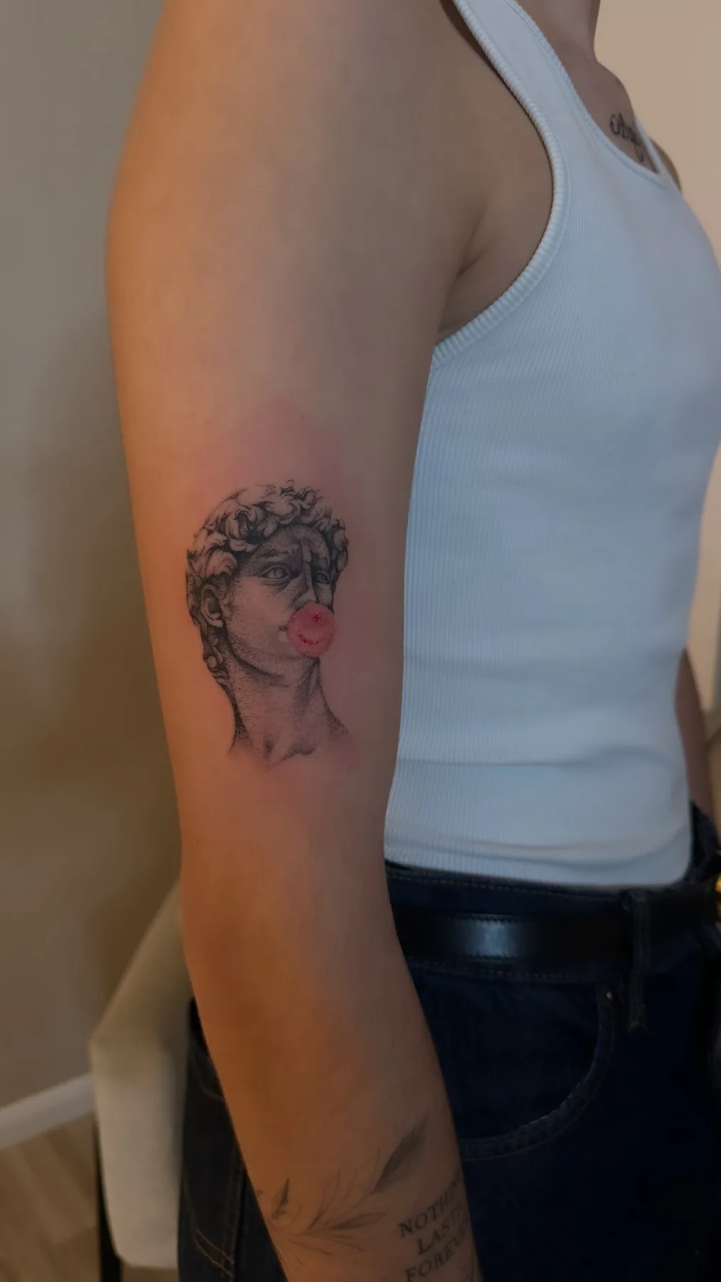 Kleines Fineline Tattoo von Elena am Oberarm